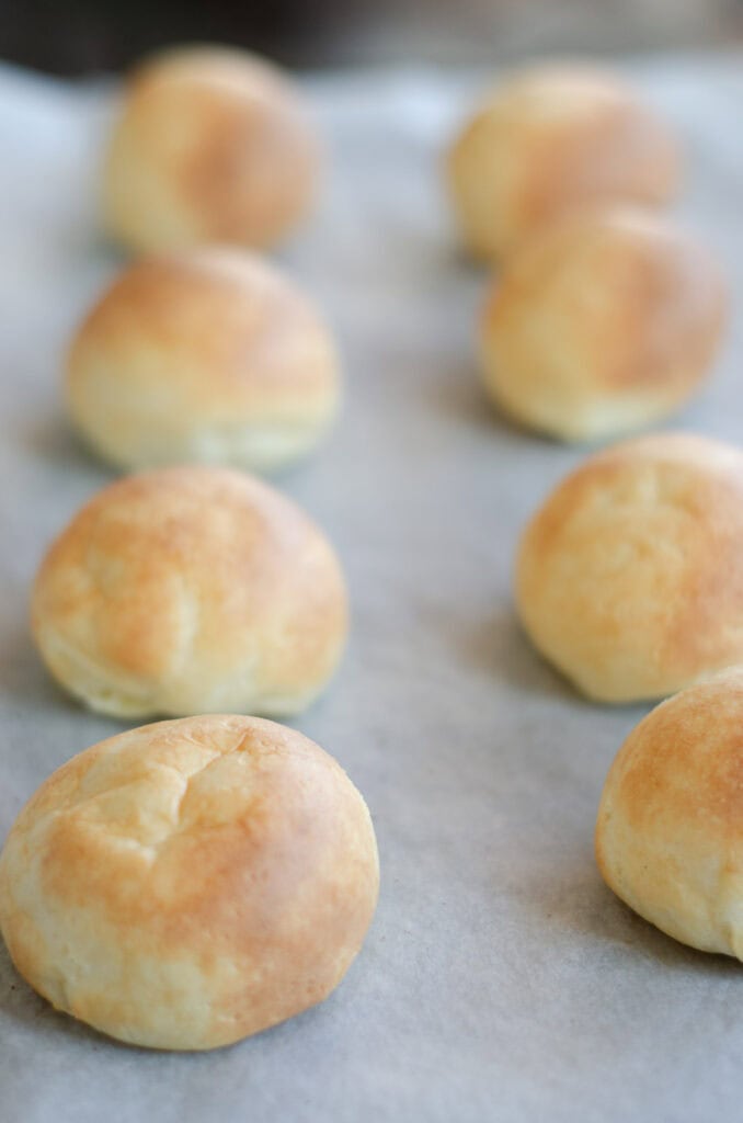 8 almojabanas on a baking sheet lined with parchment paper
