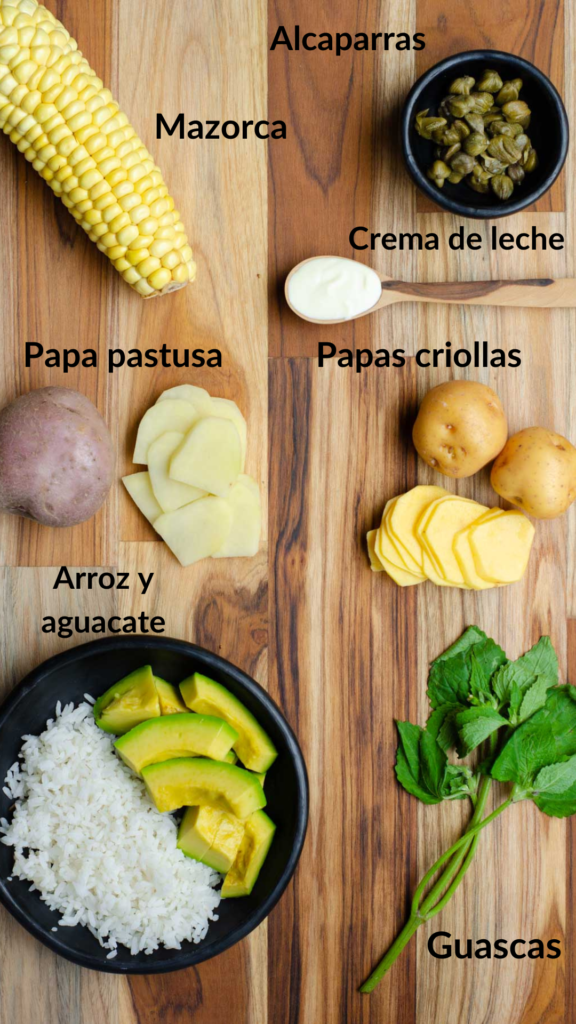 los ingredientes del ajiaco en la mesa: mazorca, alcaparras, crema de leche, papas, arroz, aguacate, guascas