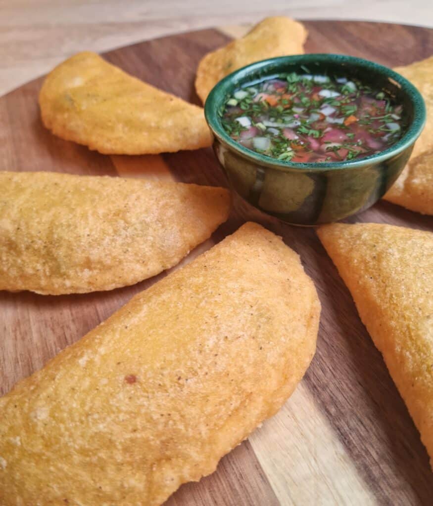 Circulo de empanadas colombianas veganas con ají picante al centro