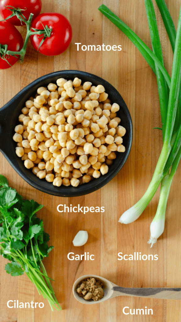 ingredients for the colombian chickpea stew: chickpeas, tomato, scallion, garlic, cumin, cilantro
