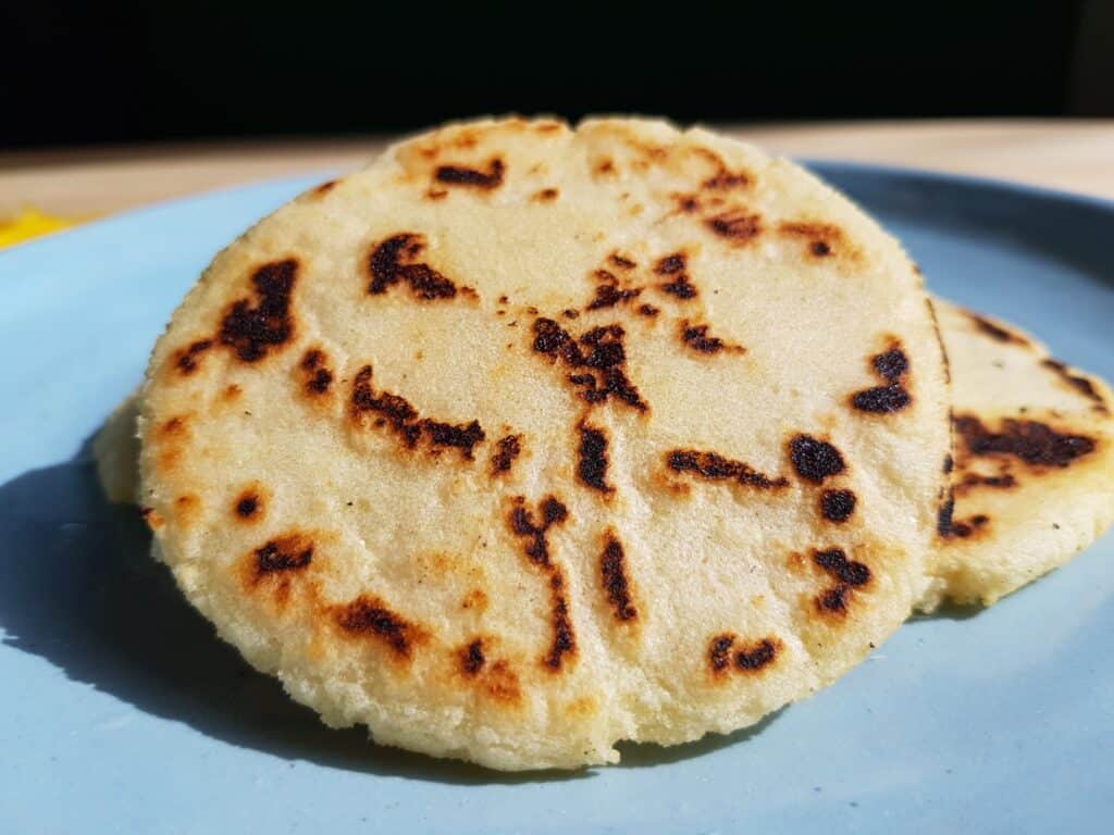 Traditional white colombian arepas on a blue plate.