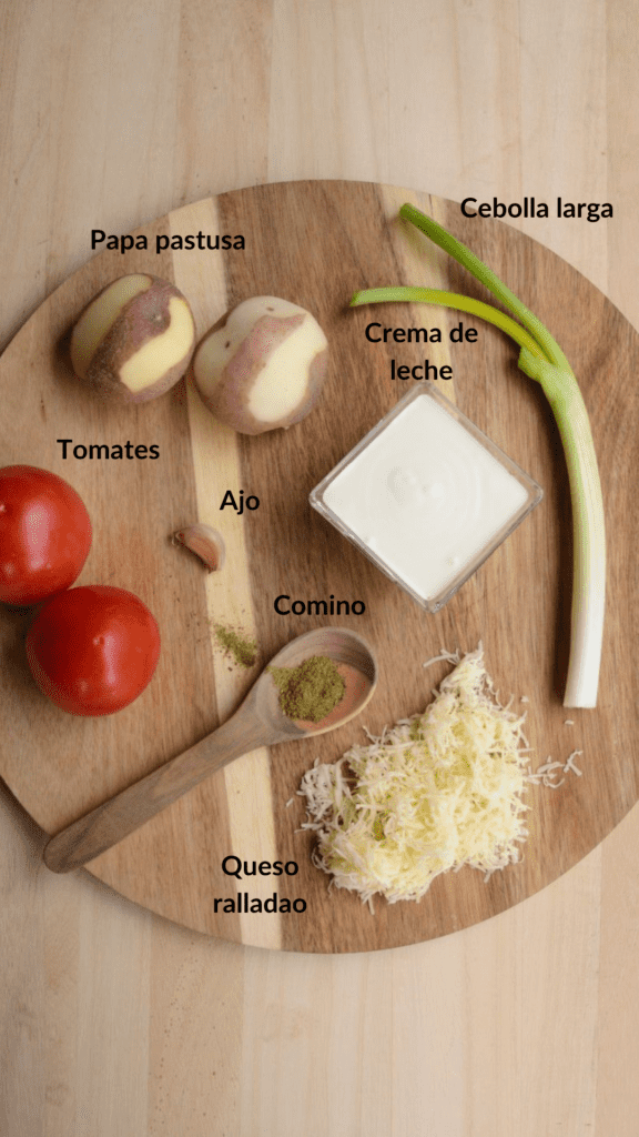 Ingredientes de papas chorreadas: papa, tomate, cebolla larga, ajo, comino, queso rallado y crema