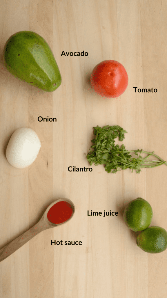 Layout with the ingredients of guacamole: avocado, tomato, cilantro, limes, hot sauce, onion