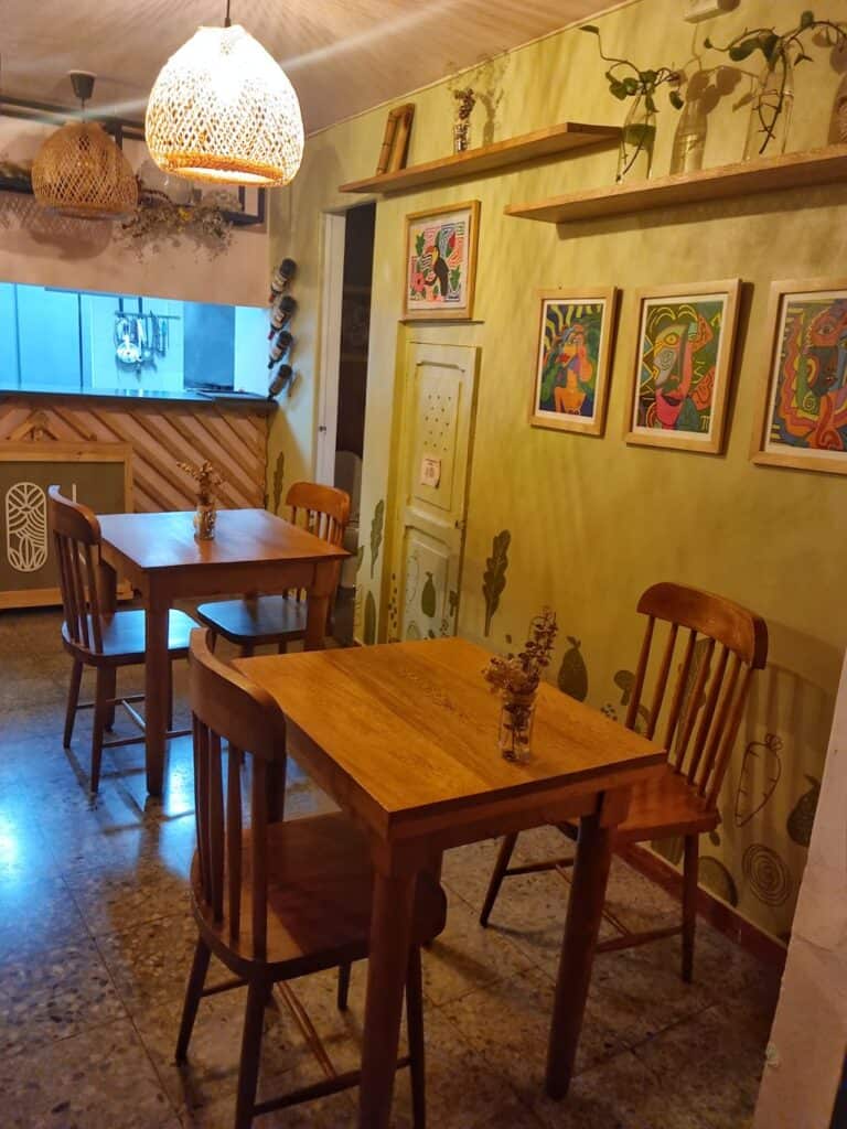 el interior de ina restaurante con mesas y sillas de madera y cuadras en la pared