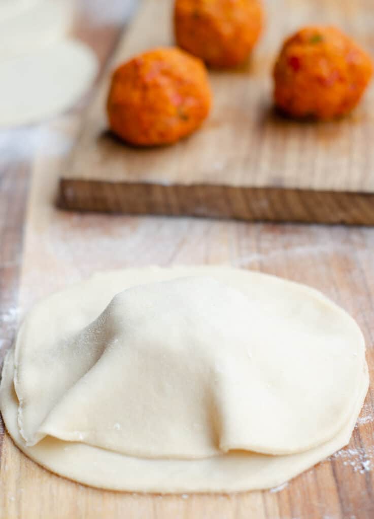 a chickpea pasty in the making with balls of filling in the background