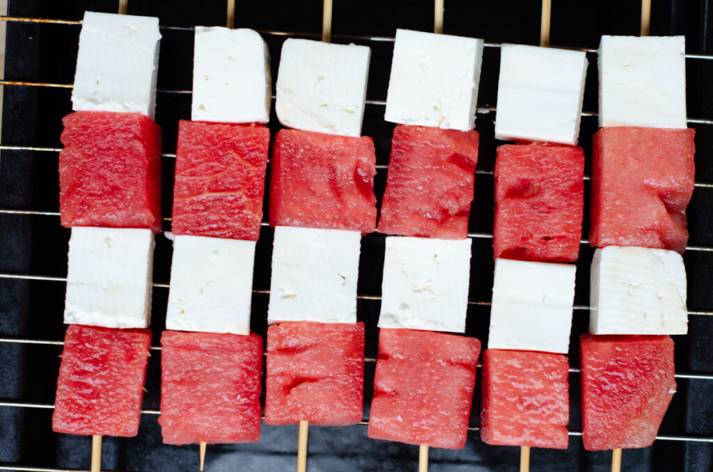 skewers with white cheese and watermelon grilled on a grill rack