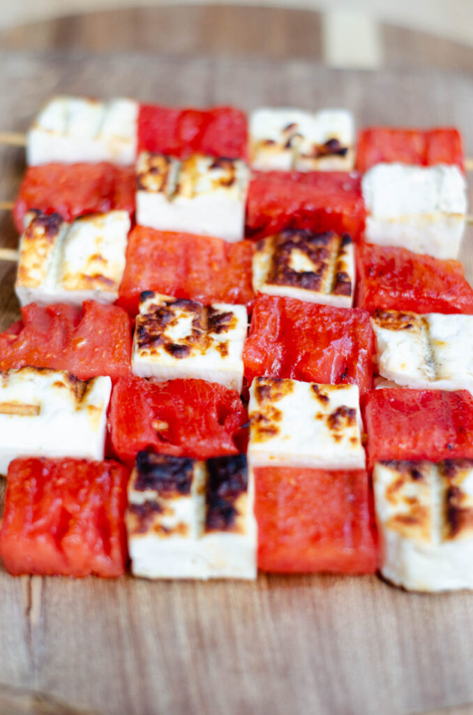 skewers with white cheese and watermelon grilled on a wooden board
