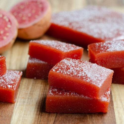 Guava Paste bocadillo blocks on a cutting board with guava fruit as decoration