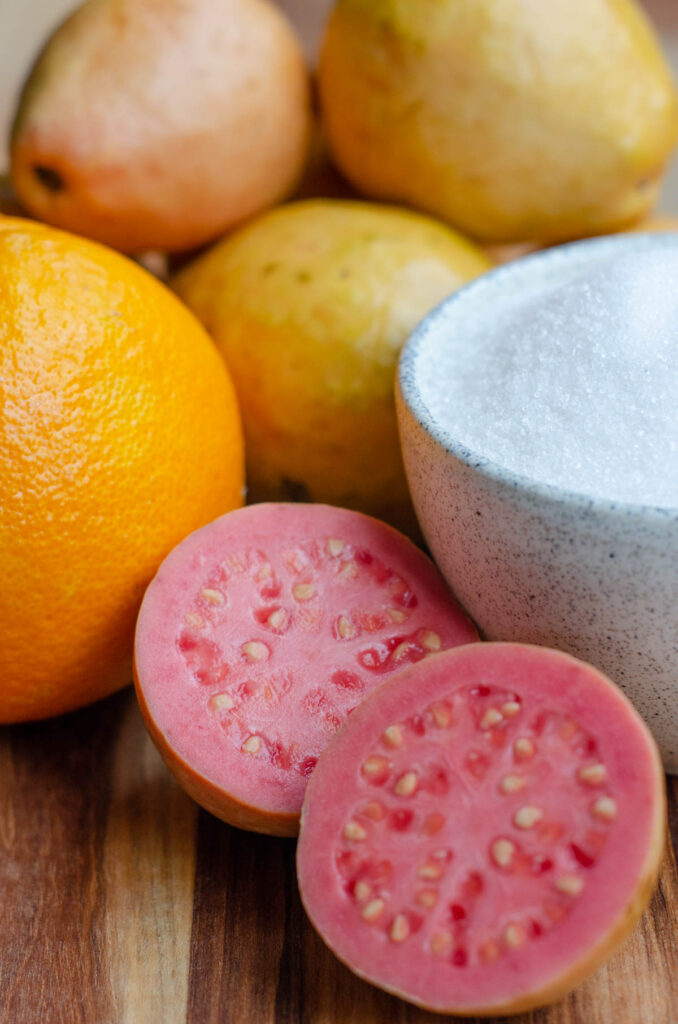the ingredients to make guava paste: guavas, orange juice and white sugar in a bowl