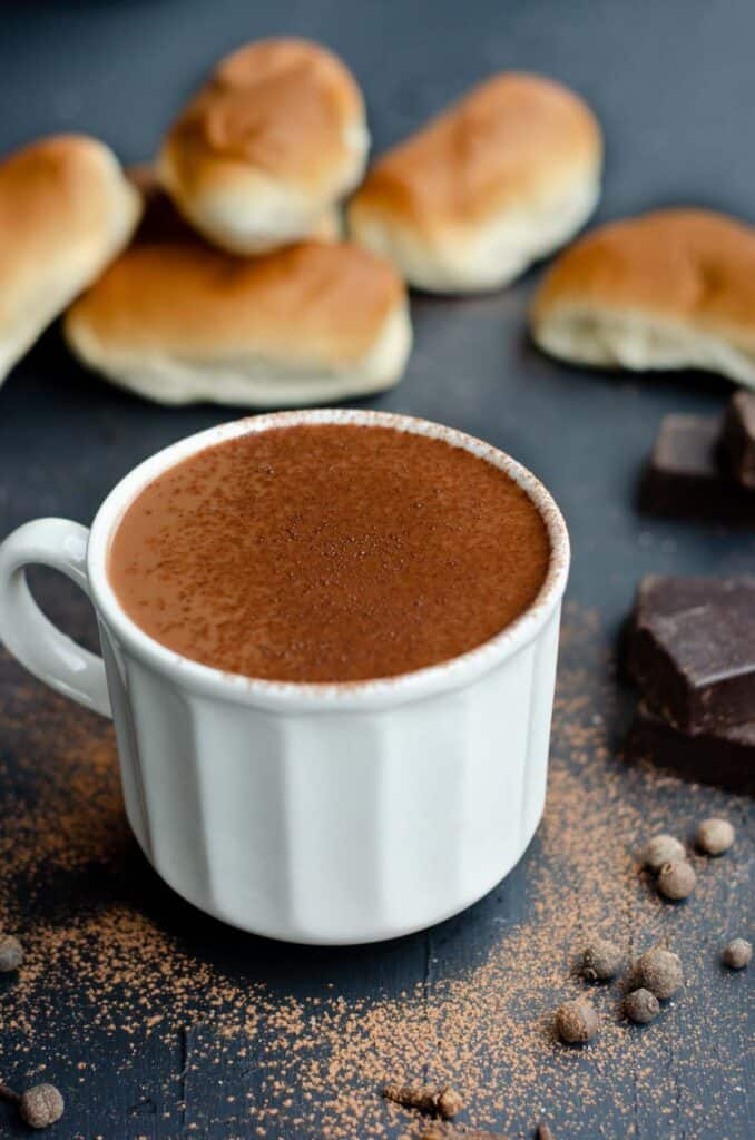 hot colombian chocolate with spices and bread rolls in the background