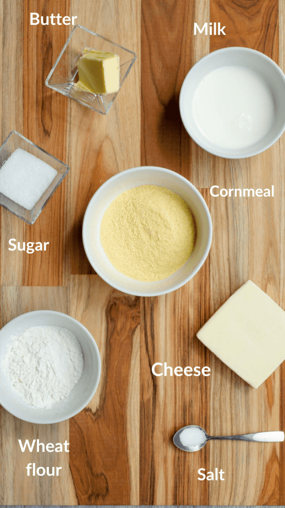 ingredients for arepas from boyaca in a wooden board: cornmeal, flour, milk, cheese, sugar, salt, butter